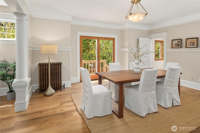 2401 10th Ave W, Seattle, WA 98119 - dining space featuring decorative columns, radiator, light wood-type flooring, and crown molding