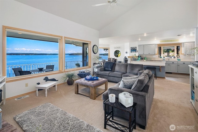 212 Tala Shore Dr, Port Ludlow, WA 98365 - living room with light carpet, a ceiling fan, high vaulted ceiling, and a water view