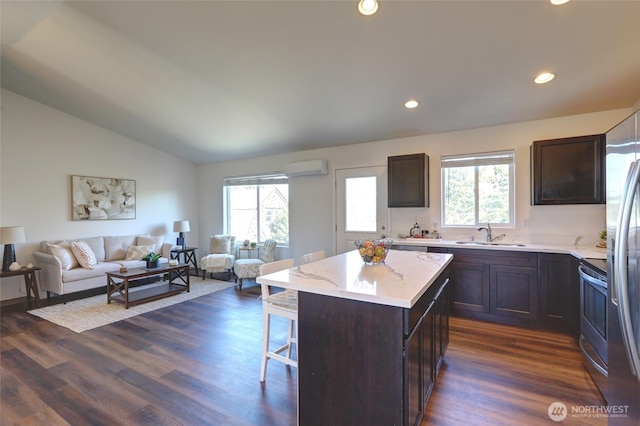 1011 S 64th St, Tacoma, WA 98408 - kitchen featuring open floor plan, vaulted ceiling, a breakfast bar area, dark brown cabinetry, and an AC wall unit