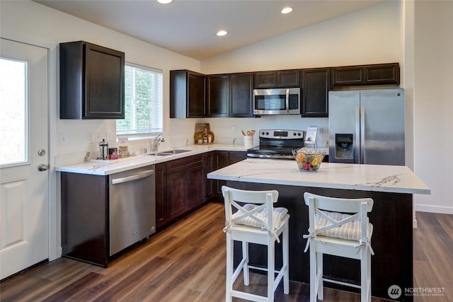 1011 S 64th St, Tacoma, WA 98408 - kitchen featuring stainless steel appliances, vaulted ceiling, dark brown cabinets, dark wood-style flooring, and light stone countertops