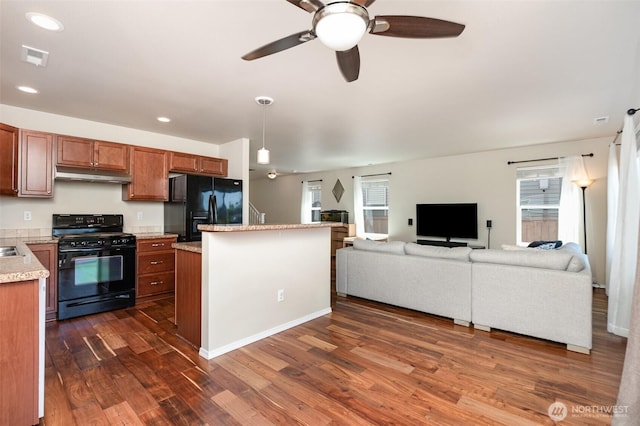 1228 81st Dr SE, Lake Stevens, WA 98258 - kitchen with black appliances, under cabinet range hood, ceiling fan, dark wood-style flooring, and brown cabinets