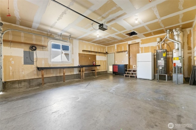 1875 Florence St, Enumclaw, WA 98022 - garage featuring freestanding refrigerator, gas water heater, electric panel, and a garage door opener
