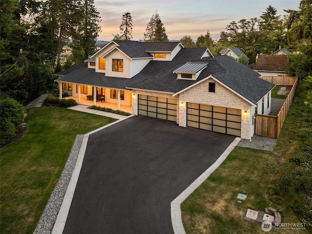 1521 8th St SW, Puyallup, WA 98371 - view of front of property with covered porch, stone siding, asphalt driveway, an attached garage, and a standing seam roof