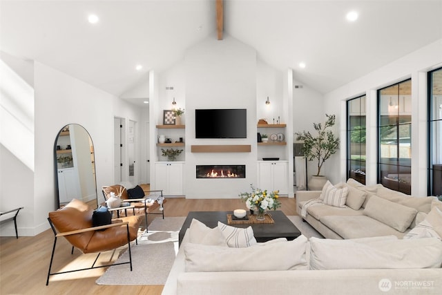 1521 8th St SW, Puyallup, WA 98371 - living area with wood finished floors, beamed ceiling, high vaulted ceiling, a glass covered fireplace, and recessed lighting