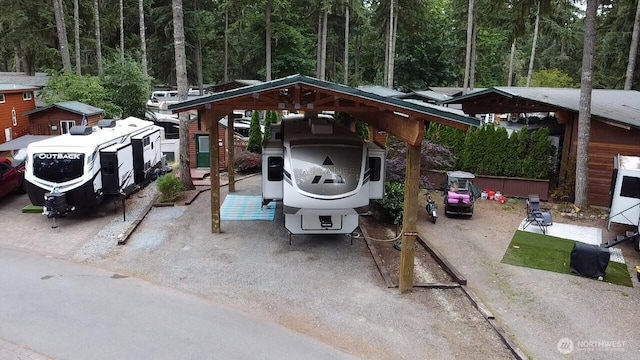 1546 Reservation Rd SE Unit 222, Olympia, WA 98513 - view of parking featuring a detached carport and a view of trees