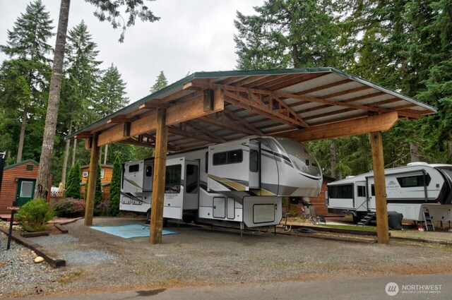 1546 Reservation Rd SE Unit 222, Olympia, WA 98513 - view of parking featuring a carport and view of scattered trees