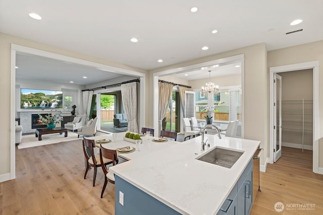 3348 218th St SE, Bothell, WA 98021 - kitchen featuring light countertops, light wood-style flooring, a glass covered fireplace, a chandelier, and recessed lighting