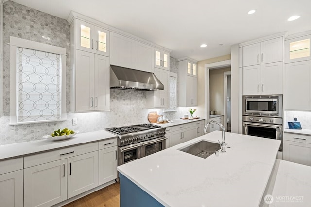 3348 218th St SE, Bothell, WA 98021 - kitchen with wall chimney exhaust hood, appliances with stainless steel finishes, tasteful backsplash, white cabinets, and light wood-style floors