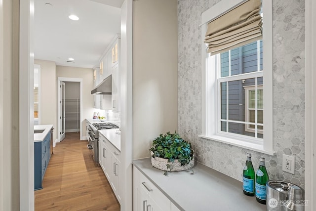 3348 218th St SE, Bothell, WA 98021 - kitchen featuring stainless steel range, under cabinet range hood, white cabinetry, light wood finished floors, and recessed lighting