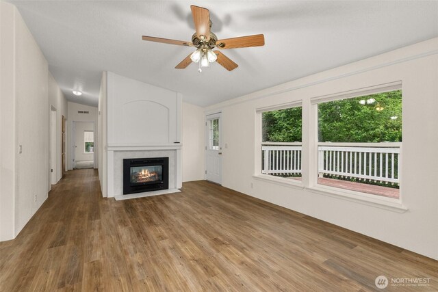 158 S Fork Rd, Raymond, WA 98577 - unfurnished living room featuring wood finished floors, a fireplace with flush hearth, and ceiling fan