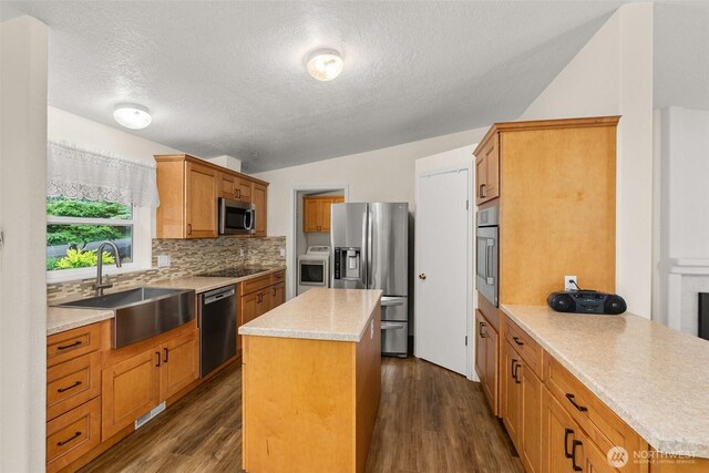 158 S Fork Rd, Raymond, WA 98577 - kitchen with stainless steel appliances, a textured ceiling, a kitchen island, light countertops, and decorative backsplash