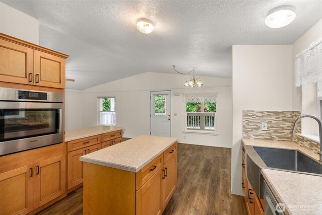 158 S Fork Rd, Raymond, WA 98577 - kitchen featuring appliances with stainless steel finishes, dark wood-type flooring, vaulted ceiling, light countertops, and a kitchen island