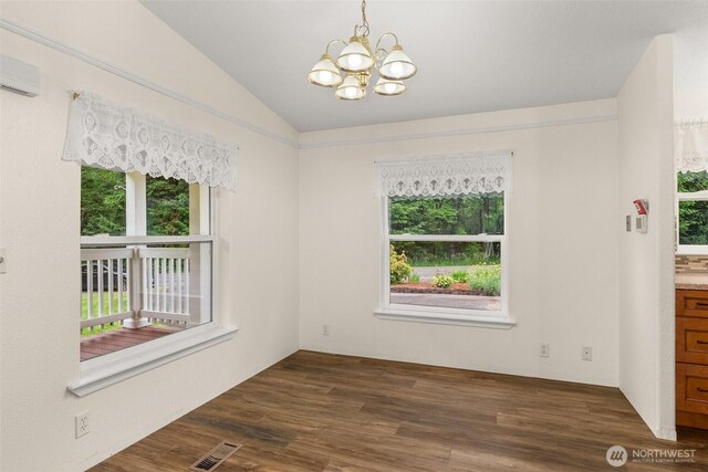 158 S Fork Rd, Raymond, WA 98577 - empty room featuring healthy amount of natural light, a chandelier, lofted ceiling, dark wood-style floors, and an AC wall unit