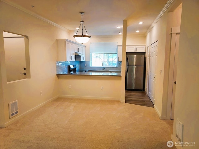 25025 SE Klahanie Blvd Unit D202, Sammamish, WA 98029 - kitchen featuring stainless steel appliances, white cabinetry, light carpet, crown molding, and a peninsula