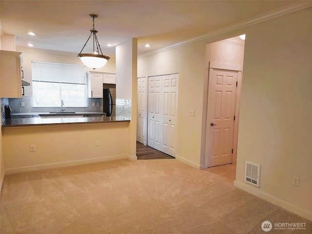 25025 SE Klahanie Blvd Unit D202, Sammamish, WA 98029 - kitchen with freestanding refrigerator, ornamental molding, tasteful backsplash, light carpet, and decorative light fixtures