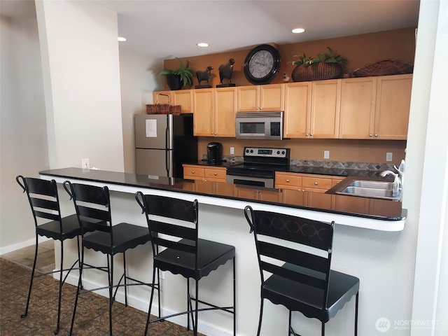 25025 SE Klahanie Blvd Unit D202, Sammamish, WA 98029 - kitchen with appliances with stainless steel finishes, light brown cabinets, dark countertops, a breakfast bar area, and recessed lighting