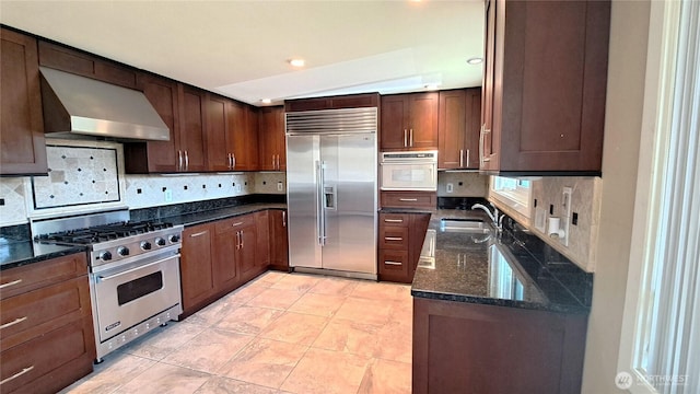 3410 Forest Ct, Bellingham, WA 98225 - kitchen featuring premium appliances, wall chimney exhaust hood, decorative backsplash, dark stone countertops, and recessed lighting