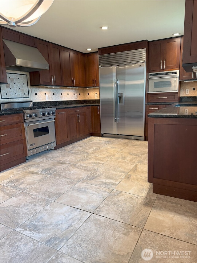 3410 Forest Ct, Bellingham, WA 98225 - kitchen with high quality appliances, ventilation hood, tasteful backsplash, dark brown cabinets, and dark stone counters
