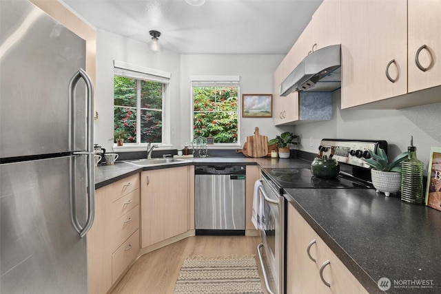 5300 Harbour Pointe Blvd Unit 311B, Mukilteo, WA 98275 - kitchen with appliances with stainless steel finishes, under cabinet range hood, light wood finished floors, dark countertops, and light brown cabinets