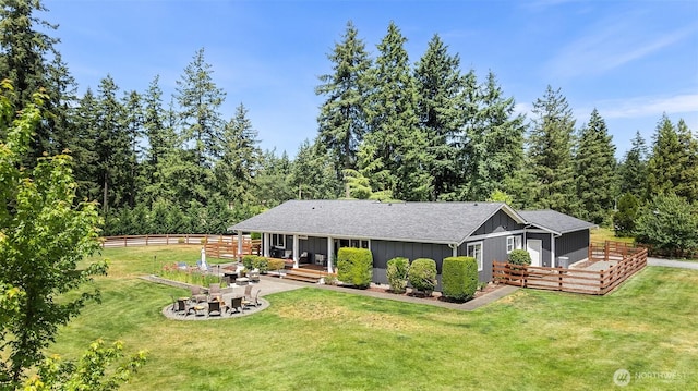 5810 246th St E, Graham, WA 98338 - back of property with board and batten siding, an outdoor fire pit, a shingled roof, and a wooden deck