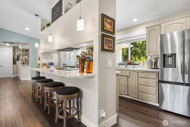 5810 246th St E, Graham, WA 98338 - kitchen with stainless steel refrigerator with ice dispenser, a breakfast bar area, light countertops, dark wood-style floors, and pendant lighting