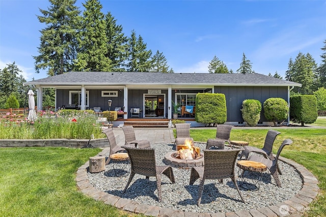 5810 246th St E, Graham, WA 98338 - back of property featuring board and batten siding, a yard, a fire pit, and roof with shingles