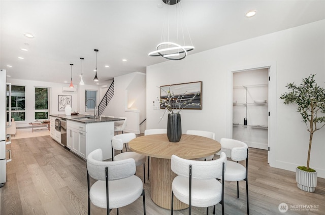 7731 NE 175th St Unit 102, Kenmore, WA 98028 - dining space with light wood-style floors, recessed lighting, and stairway