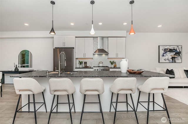 7731 NE 175th St Unit 102, Kenmore, WA 98028 - kitchen featuring wall chimney range hood, a breakfast bar area, a kitchen island with sink, stove, and tasteful backsplash