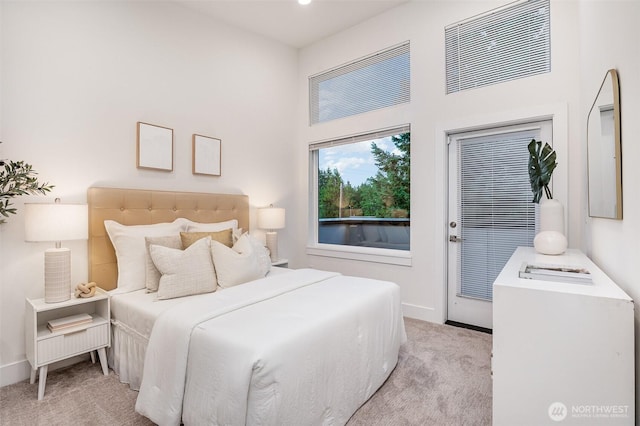 7731 NE 175th St Unit 102, Kenmore, WA 98028 - bedroom featuring light colored carpet, access to exterior, and a high ceiling