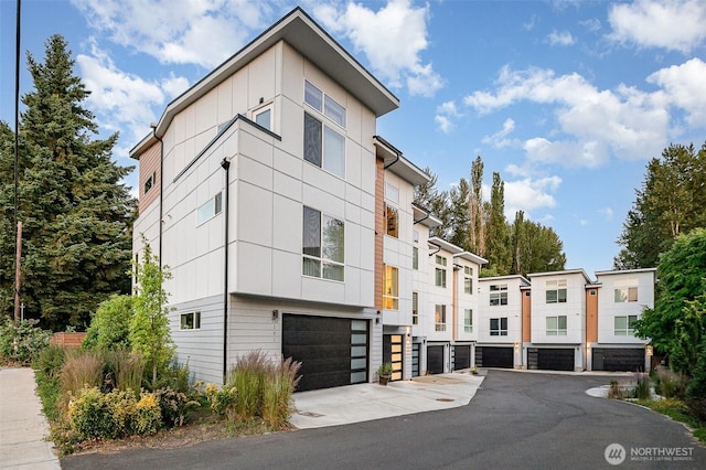 7731 NE 175th St Unit 102, Kenmore, WA 98028 - view of property featuring a garage and driveway