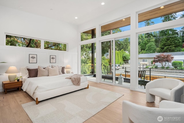 3983 162nd Pl SE, Bellevue, WA 98006 - bedroom with access to exterior, multiple windows, a towering ceiling, wood finished floors, and recessed lighting