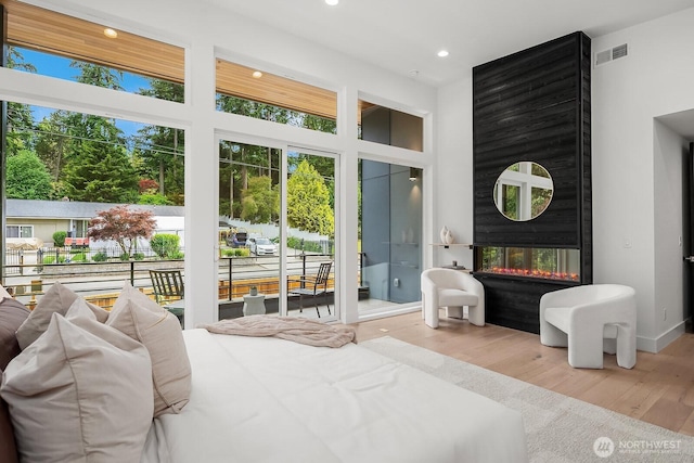 3983 162nd Pl SE, Bellevue, WA 98006 - bedroom with access to outside, wood finished floors, recessed lighting, and a multi sided fireplace