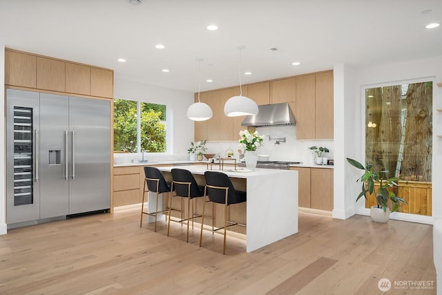 3983 162nd Pl SE, Bellevue, WA 98006 - kitchen with built in refrigerator, wall chimney exhaust hood, modern cabinets, and recessed lighting