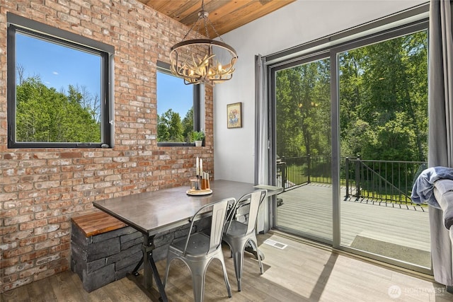 1712 Nelson Siding Rd, Cle Elum, WA 98922 - dining space with a chandelier, wooden ceiling, wood finished floors, brick wall, and vaulted ceiling