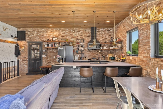 1712 Nelson Siding Rd, Cle Elum, WA 98922 - indoor wet bar featuring freestanding refrigerator, wooden ceiling, brick wall, light wood finished floors, and ventilation hood