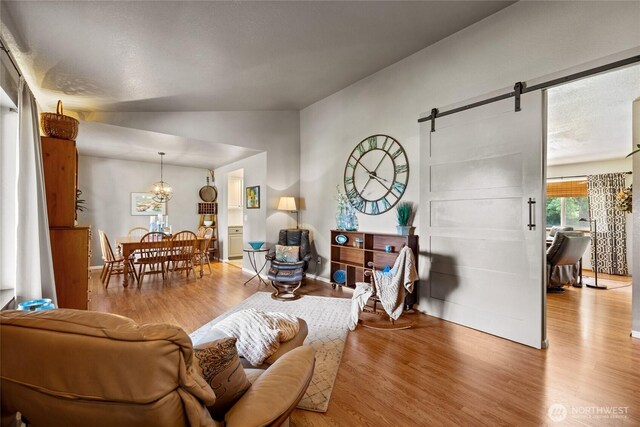 16325 Tareyton Ln SE, Yelm, WA 98597 - living room with wood finished floors, a barn door, a chandelier, and lofted ceiling