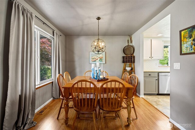 16325 Tareyton Ln SE, Yelm, WA 98597 - dining room with light wood finished floors, healthy amount of natural light, and a chandelier