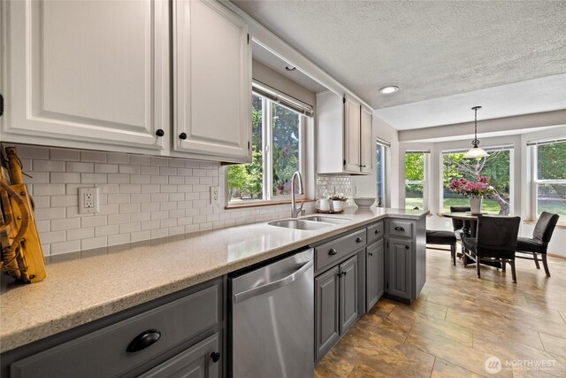 16325 Tareyton Ln SE, Yelm, WA 98597 - kitchen featuring dishwasher, gray cabinetry, plenty of natural light, backsplash, and a textured ceiling