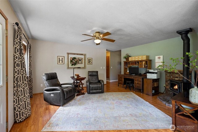 16325 Tareyton Ln SE, Yelm, WA 98597 - living area with a wood stove, ceiling fan, and wood finished floors