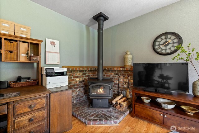 16325 Tareyton Ln SE, Yelm, WA 98597 - living room with a wood stove, wood finished floors, and a textured ceiling