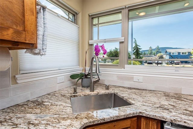 516 E Willow St, Sequim, WA 98382 - kitchen with decorative backsplash, light stone counters, and brown cabinets