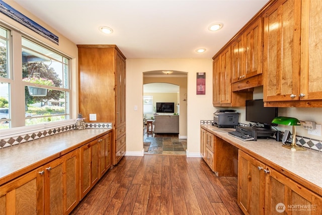 516 E Willow St, Sequim, WA 98382 - kitchen featuring dark wood-type flooring, arched walkways, brown cabinets, light countertops, and recessed lighting