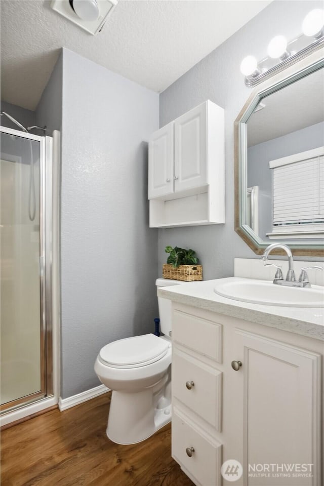 18401 Rampart Dr SE, Yelm, WA 98597 - bathroom with a shower stall, vanity, wood finished floors, a textured ceiling, and a textured wall