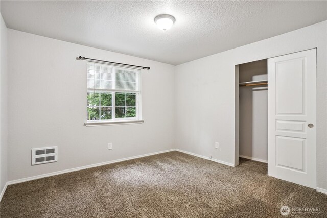 18401 Rampart Dr SE, Yelm, WA 98597 - unfurnished bedroom featuring a textured ceiling, carpet, a closet, and heating unit