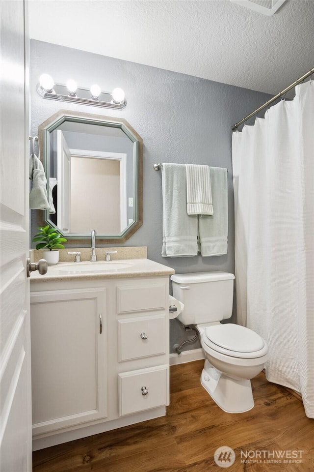 18401 Rampart Dr SE, Yelm, WA 98597 - full bathroom featuring wood finished floors, vanity, a shower with shower curtain, a textured wall, and a textured ceiling