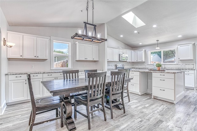 87 N Mary Ave, East Wenatchee, WA 98802 - dining space featuring a skylight, lofted ceiling, light wood-type flooring, recessed lighting, and a textured ceiling