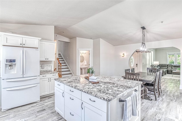 87 N Mary Ave, East Wenatchee, WA 98802 - kitchen with white fridge with ice dispenser, light wood-type flooring, white cabinets, light stone counters, and vaulted ceiling