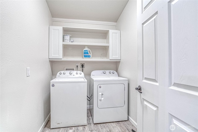 87 N Mary Ave, East Wenatchee, WA 98802 - laundry area with cabinet space, washer and clothes dryer, light wood finished floors, and crown molding