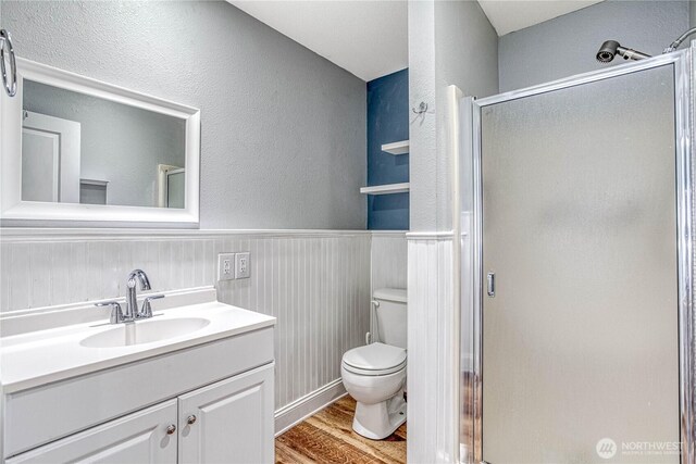 87 N Mary Ave, East Wenatchee, WA 98802 - bathroom featuring wood finished floors, a shower stall, vanity, a textured wall, and wainscoting