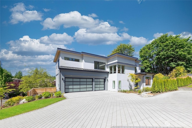 10204NE 43rd St, Kirkland, WA 98033 - contemporary home featuring a garage, driveway, a metal roof, a standing seam roof, and stucco siding